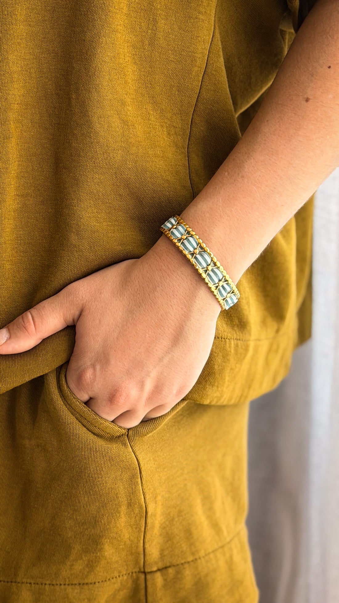 Bracelet jonc en acier inoxydable habillé de tissu upcyclé, porté au poignet