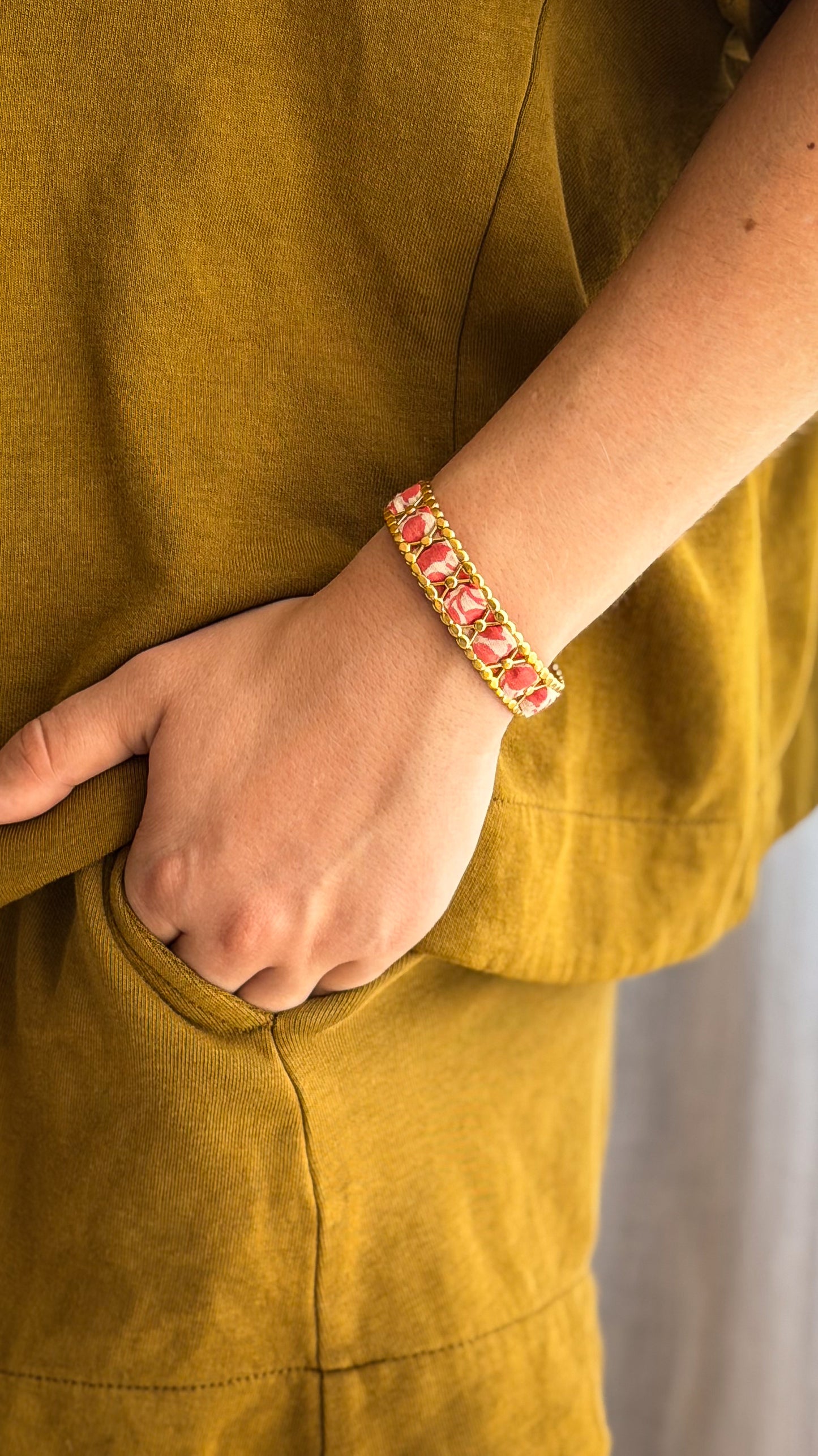 Bracelet jonc en acier inoxydable et tissu upcyclé motif fleurs roses, porté au poignet