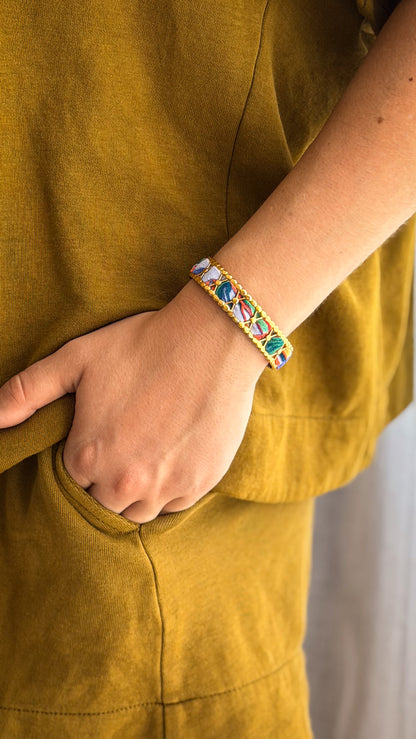Bracelet jonc en acier inoxydable et tissu upcyclé motif fleurs bleu et corail, porté au poignet