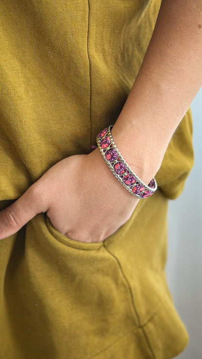 Bracelet jonc en acier inoxydable et tissu upcyclé argenté motif fleurs prune, porté au poignet