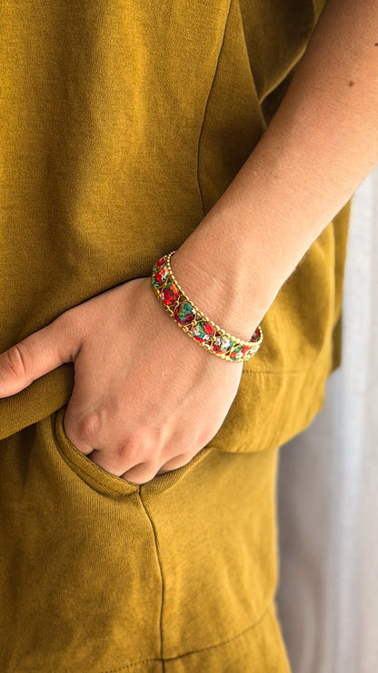 Bracelet jonc en acier inoxydable et tissu upcyclé motif fleurs rouges, porté au poignet