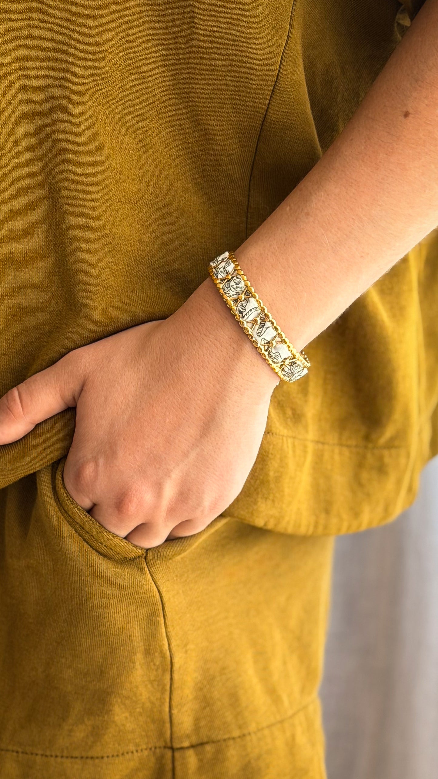 Bracelet jonc en acier inoxydable et tissu upcyclé motif herbier noir et blanc, porté au poignet