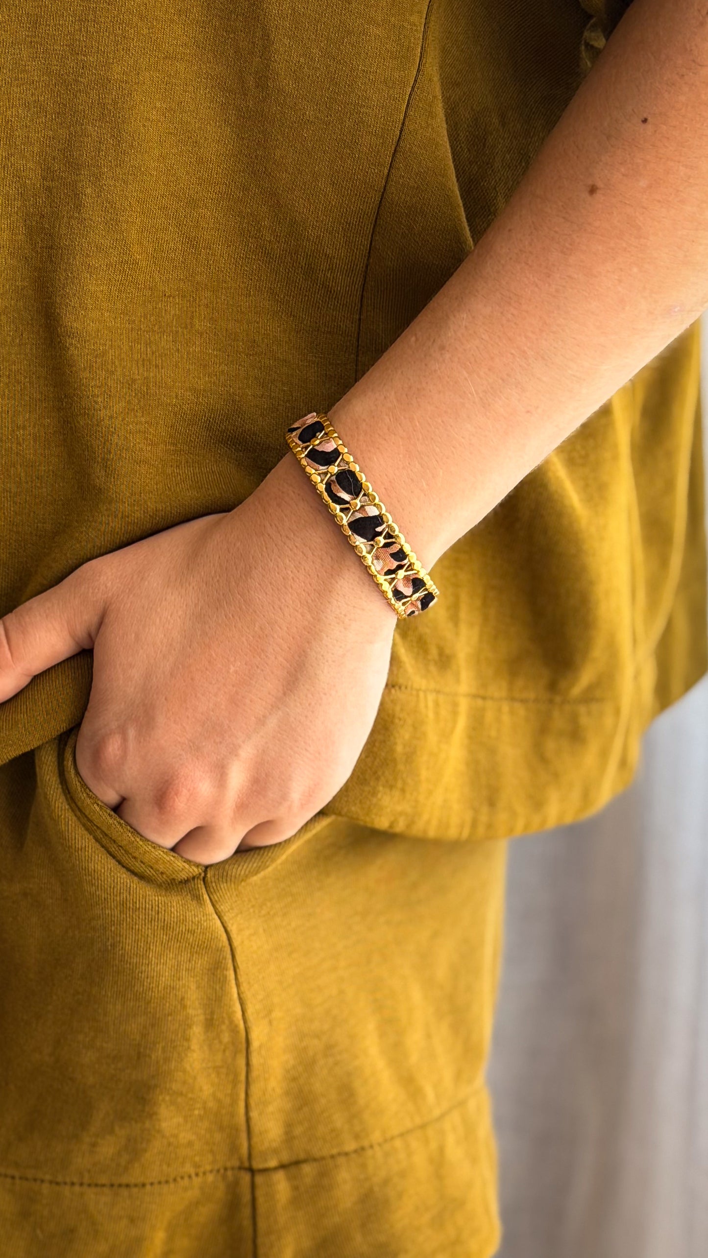 Bracelet jonc en acier inoxydable et tissu upcyclé motif léopard, porté au poignet