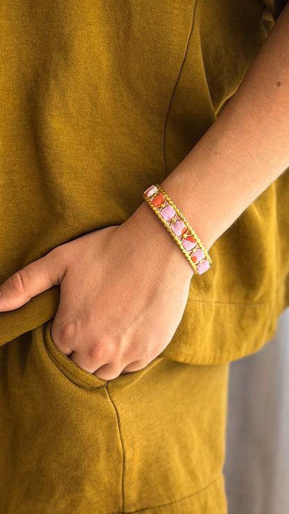 Bracelet jonc en acier inoxydable et tissu upcyclé motif rose corail, porté au poignet
